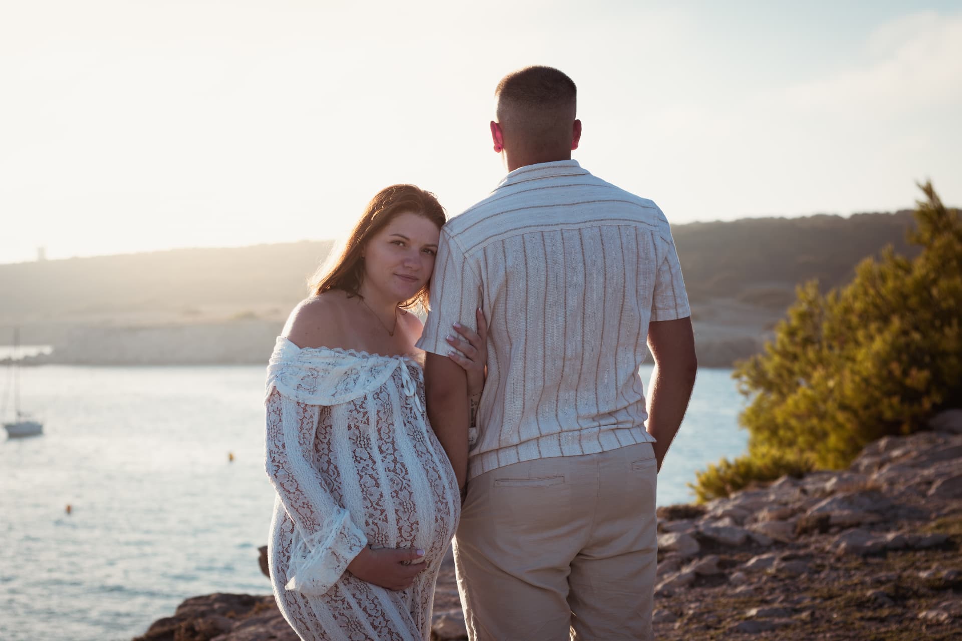 Couple enlacé au bord de la mer au coucher du soleil, séance grossesse en Provence